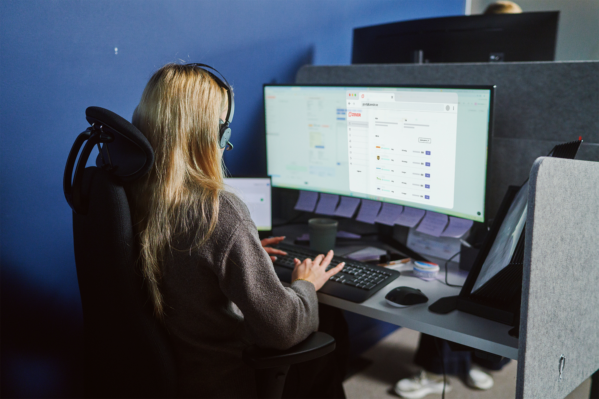 Person jobbar med Zendrs portal på stor skärm.